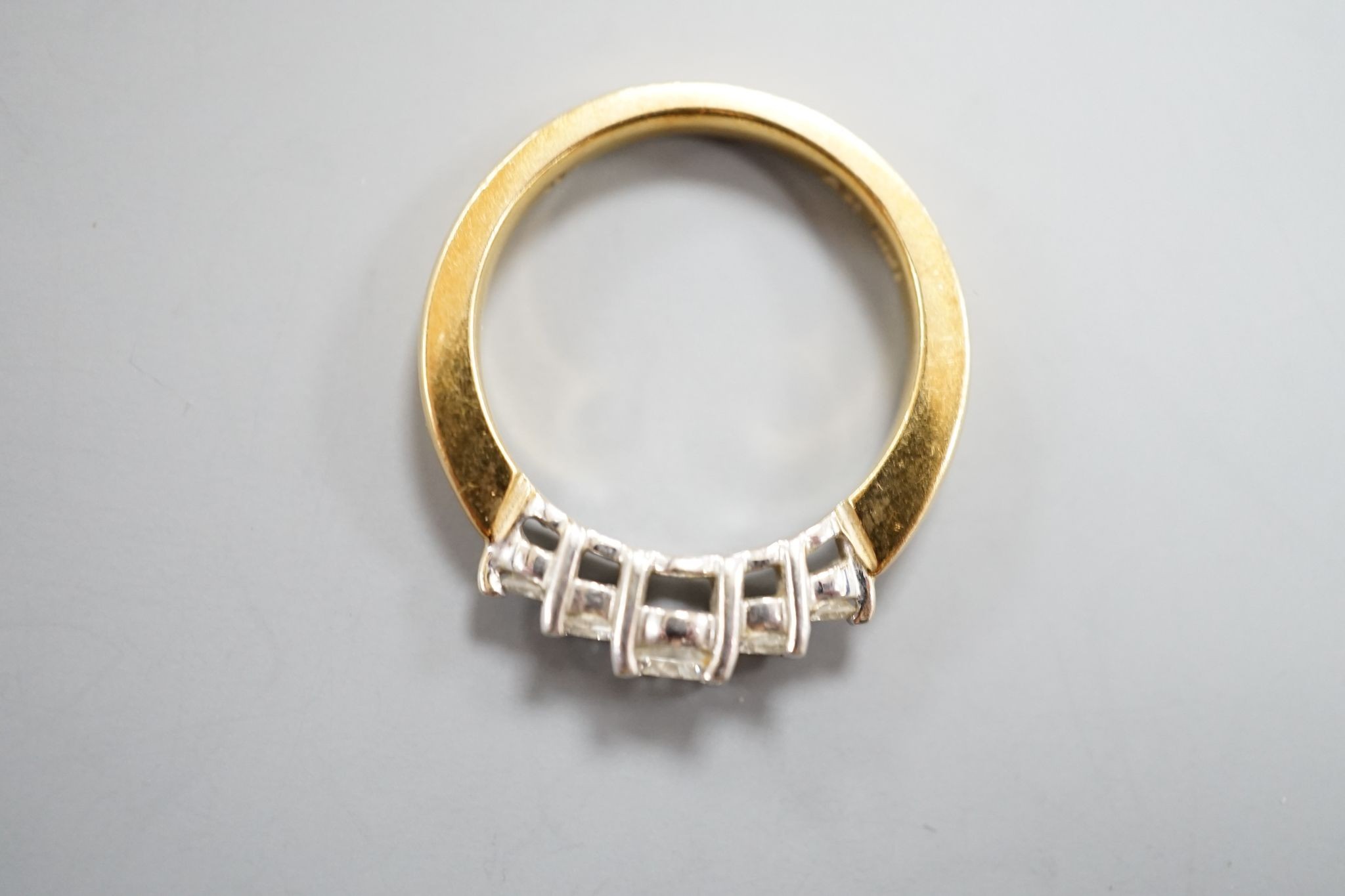 A modern 18k yellow metal and graduated five stone diamond set half hoop ring, size N, gross weight 5.4 grams.